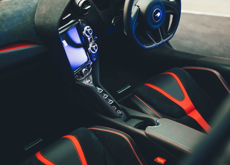 Discover the elegant interior of a McLaren supercar, featuring advanced dashboard and seating.