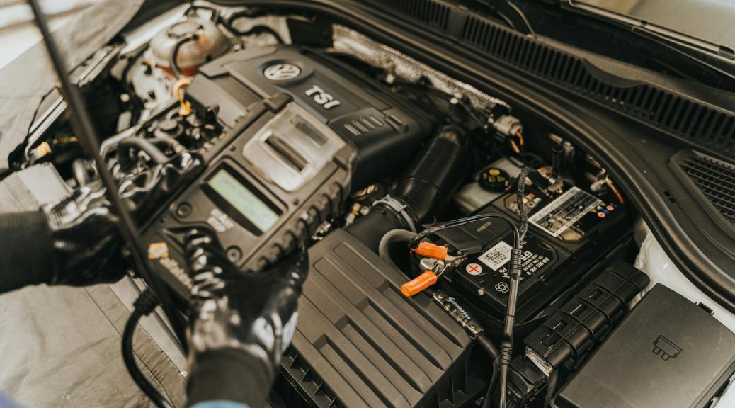 Close-up view of a mechanic diagnosing a Volkswagen engine with specialized equipment.