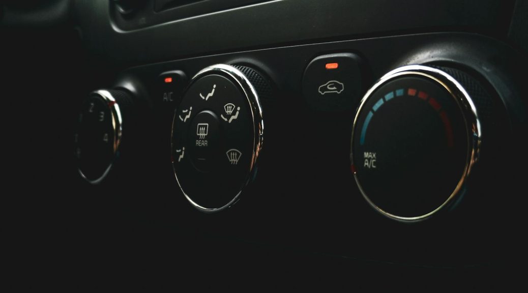 Detailed close-up of car dashboard controls featuring buttons, dials, and indicators.