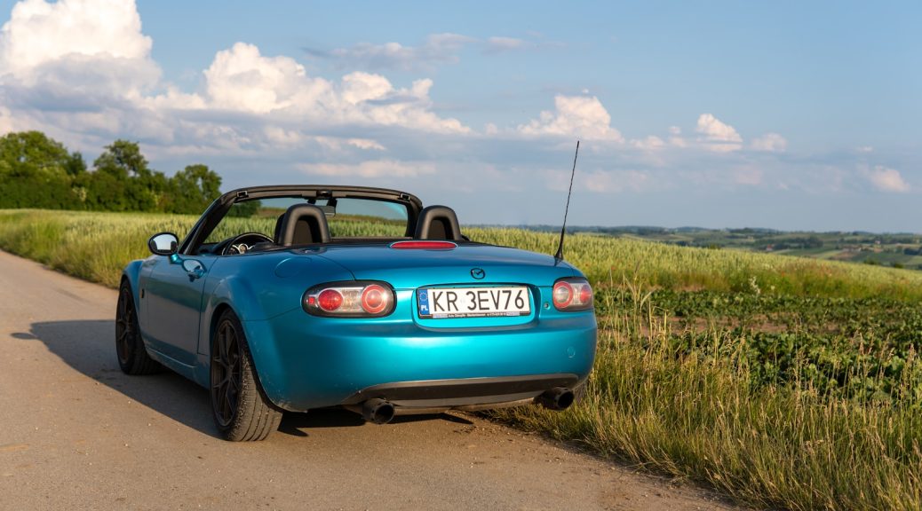 a blue sports car parked on the side of the road