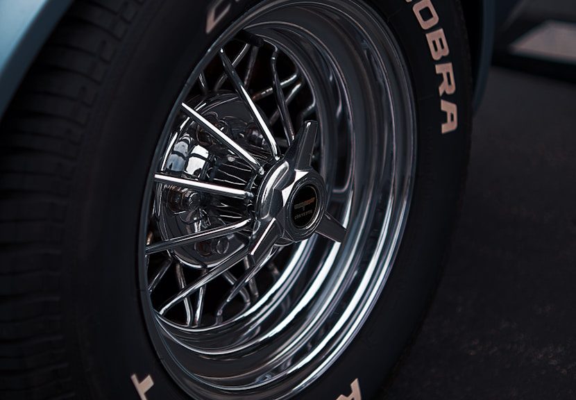 Close-up of a vintage car's chrome wheel.